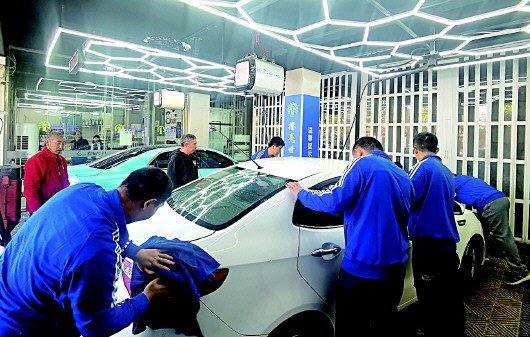Workers at Xihan’er Carwash in Qingdao clean a vehicle as part of an employment program for people with intellectual disabilities.